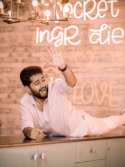 A hilarious, staged shot of the bride pulling the groom by his leg as he lies on a kitchen counter, showcasing a fun, quirky concept.