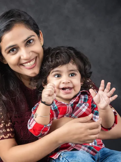 A happy portrait of a mother and her child, both sharing a beautiful, genuine smile.