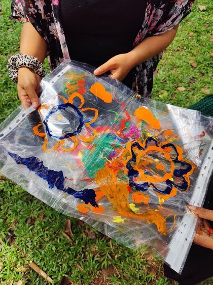 A colorful artwork created during our community circle, held up against the natural backdrop of the park.