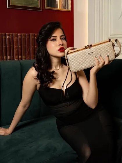 A commercial product-focused shoot for Lavie handbags featuring influencer Uorfi Javed. The image balances celebrity presence with clear product visibility for a brand campaign.