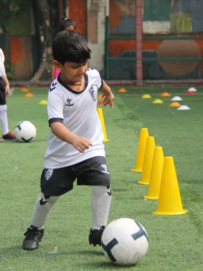 A player practices dribbling through a line of cones, a classic drill that is fundamental for developing speed and control on the ball.