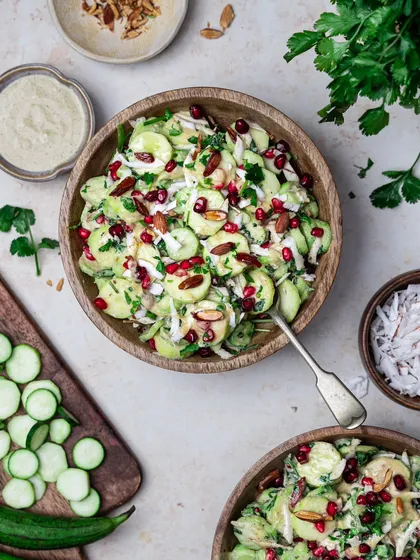 A beautiful and fresh cucumber salad in a wooden bowl. The top-down perspective shows off all the colorful ingredients, making it look like a healthy and delicious Buddha bowl.
