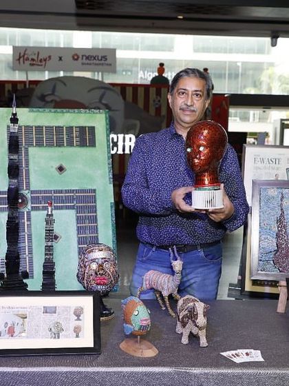 A photo from my exhibition at Nexus Mall, where I'm holding a red bust sculpture. The event was a great success and attracted a diverse audience.