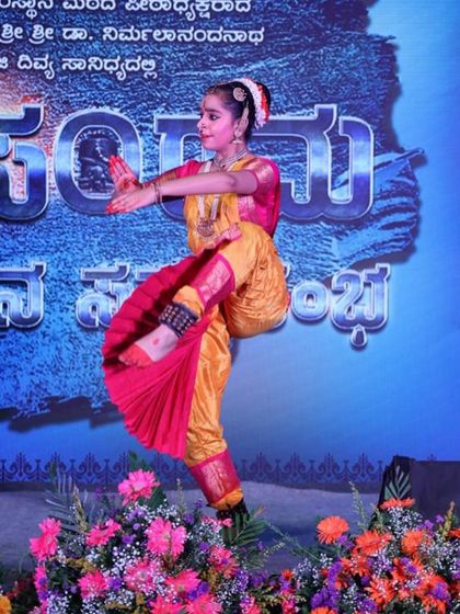 A dynamic action shot of a young dancer on stage, capturing a moment of energetic movement during her performance.