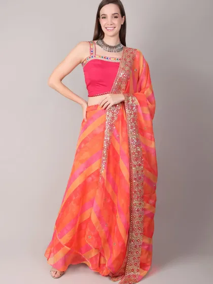 A bright and cheerful orange and pink lehenga for a vibrant Navratri look. The model's smile captures the joyful spirit of the festival.