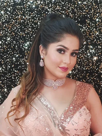 A model wearing a delicate rose gold diamond choker with a matching peach-colored sequin saree. This is a subtle and elegant look for any party.