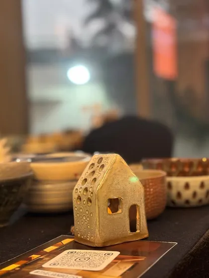 A tiny ceramic house, glowing like a lantern. A magical creation from one of our workshops.