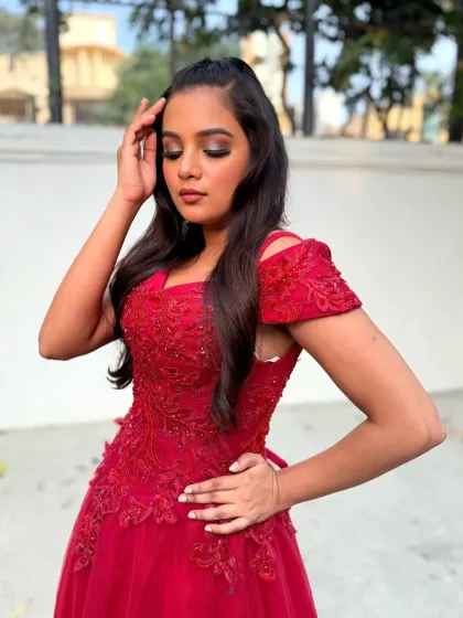 Another angle of this stunning red gown look, showing the intricate details of the dress and the flawless makeup.
