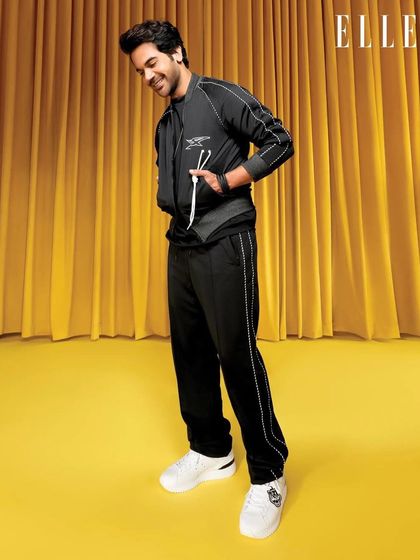 A full-length view of the black Onitsuka Tiger tracksuit for ELLE India. This look emphasizes comfort and style, perfect for showcasing modern athleisure in a fashion editorial context.