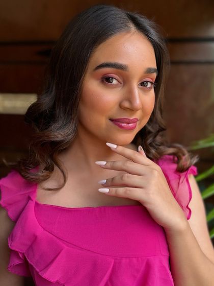 This portrait shows the complete look, with soft waves and clean makeup. It's a perfect example of a fresh and youthful party look.