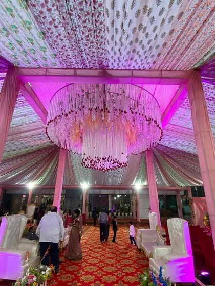 A view of the floral chandelier from the ground, showing how it serves as a grand centerpiece for the entire tent.