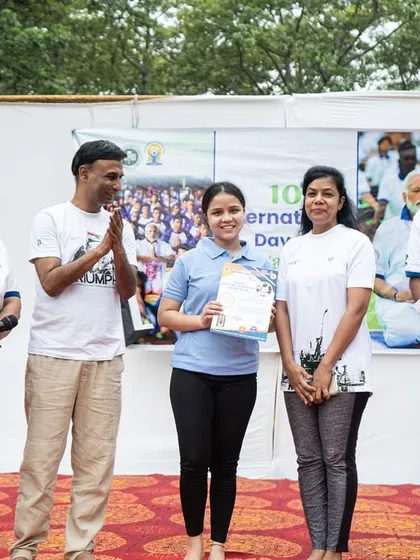 A student receiving her certificate on stage, a moment of recognition for her participation and skill.