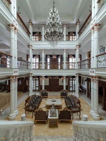 Looking down from the grand staircase, this view captures the sheer volume and symmetry of the living hall, with the massive chandelier as the central jewel.