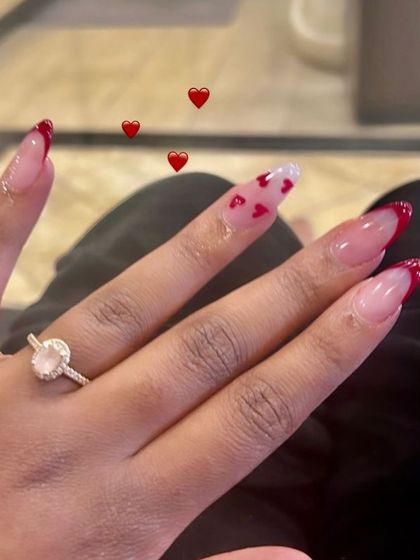 A romantic set with a red French tip and a floating hearts accent nail.