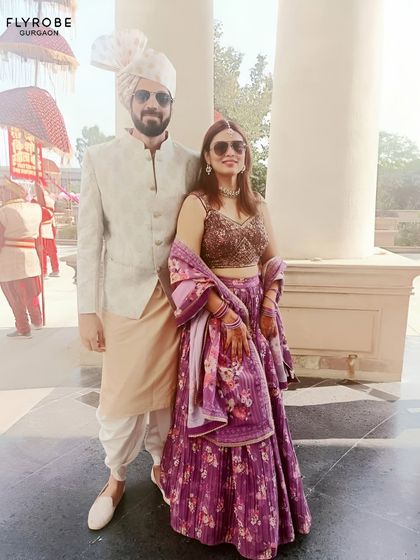 Here’s a great example of coordinating for a daytime event. The groom’s subtle patterned bandhgala and the bride’s floral print purple lehenga create a fresh, modern, and stylish couple look.