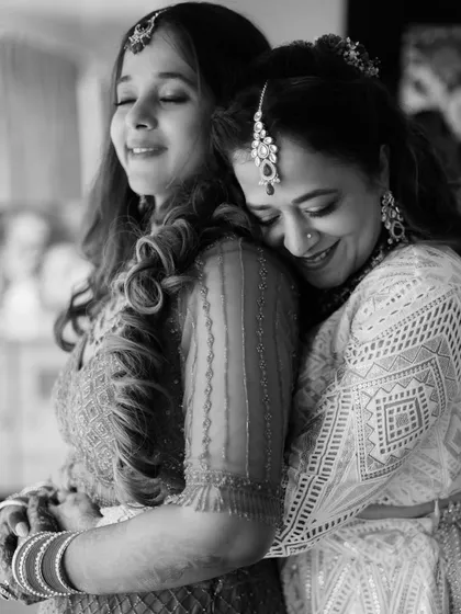 A heartfelt black and white image of a bride and her mother sharing a tight, emotional hug. This photo beautifully captures the deep bond between a mother and daughter on a wedding day.