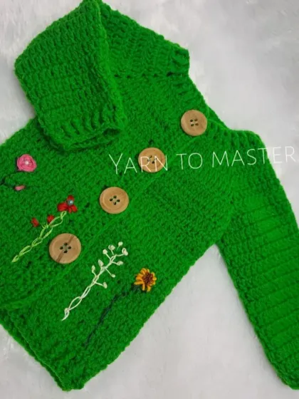 A closer look at the details on my embroidered green sweater, featuring wooden buttons and a variety of stitched wildflowers to create a unique, garden-like feel.