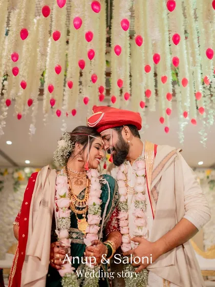 A romantic portrait of a Maharashtrian couple under a beautiful ceiling of hanging flowers after their wedding ceremony.