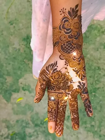 A beautiful example of a full bridal hand, where the design flows from the wrist to the fingertips. The central floral motif is a classic and timeless choice.