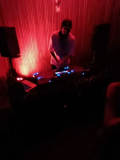 A full view of my DJ booth during a throwback set. I enjoy the simplicity of a dark room, good speakers, and a crowd that's ready to vibe.