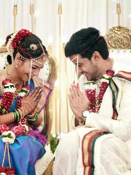 A traditional greeting, a shared smile. This moment during the ceremony is full of respect and joy, beautifully captured in a symmetrical and elegant composition.