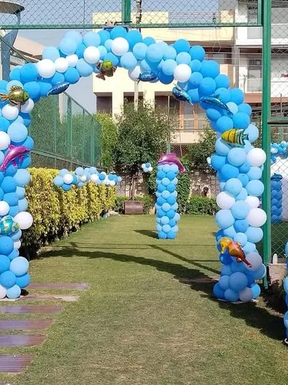 An impressive under-the-sea themed entrance walkway for Nikhil's birthday. We lined the path with multiple blue balloon arches and pillars, decorated with fish and dolphin foil balloons to create an underwater tunnel effect.