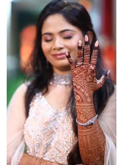 Love is in the details. A beautiful shot of a bride showcasing her engagement ring and intricate mehendi.
