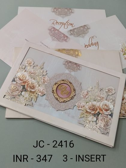 An off-white framed invitation with a stunning 3D floral arrangement and a custom monogram. This three-insert card set has a delicate and luxurious feel, perfect for a high-end wedding.