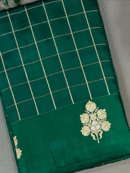 A beautiful checks pattern Banarasi saree in a rich bottle green with embroidered butas on the border.