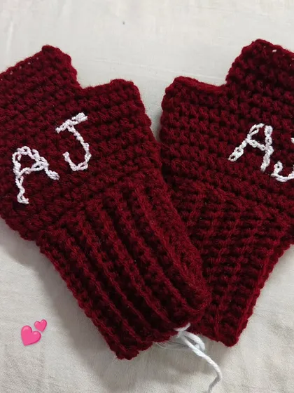 A pair of personalized fingerless gloves in a rich maroon color, with the initials 'AJ' stitched in white. This is a perfect example of the custom work I love to do.