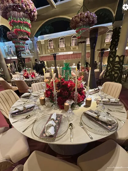 For Jeet Adani and Diva Shah’s Sangeet, we designed a sit down dinner that was both grand and intimate. The tablescape, with its deep red florals and warm candlelight, set the stage for an evening of refined taste and celebration.