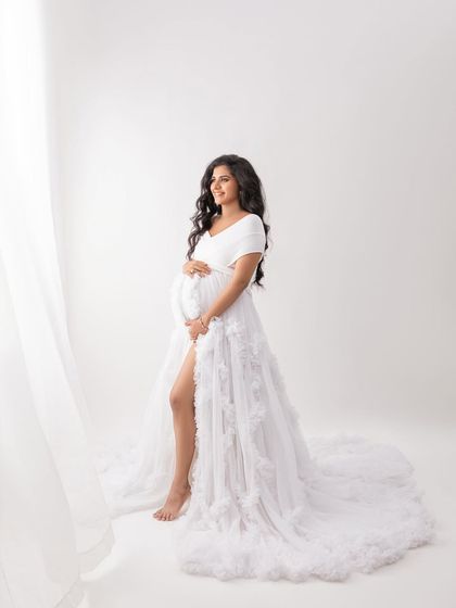 A standing pose that shows off the beautiful slit and flow of the white gown. The sheer curtains add a layer of softness to the image.