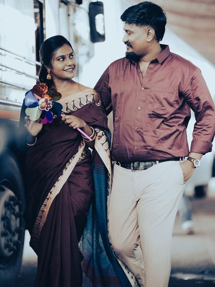 A candid shot of a couple walking by a bus, the bride holding a pinwheel, adding a touch of playful, retro charm.