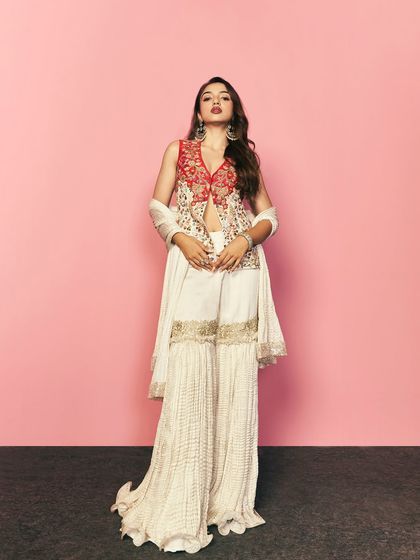 A full length view of the red and white embroidered sharara set. The combination of a fitted jacket with flowing pants is a contemporary silhouette I often recommend for festive events.