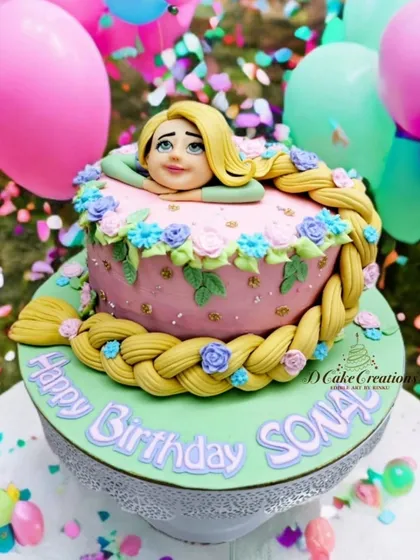 A creative Rapunzel-themed cake for Sonali's birthday. The cake is designed to look like Rapunzel's tower, with her long, braided hair wrapping around it.