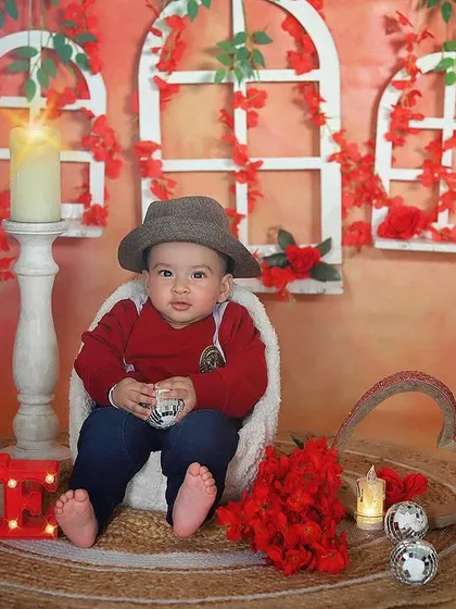 A cool little dude in our Valentine's setup. The red accents, glowing "LOVE" sign, and his stylish hat create a fun and charming look for this sitter session.