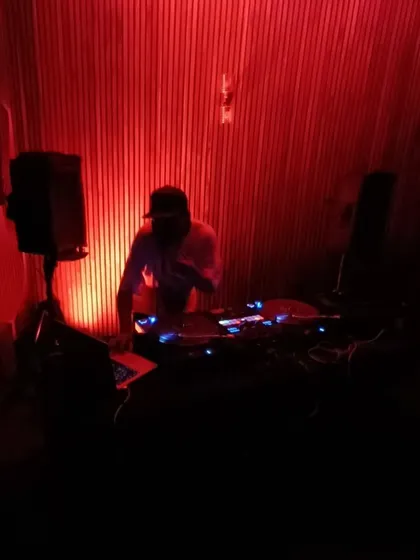 Me in the booth, surrounded by red light, spinning for a "Strictly Hip Hop" night. It's all about creating the right atmosphere for the music.