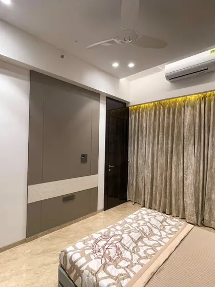 A view from the foot of the bed, showing the integrated wall paneling and the cozy study corner. The design maximizes the use of space without feeling cluttered.