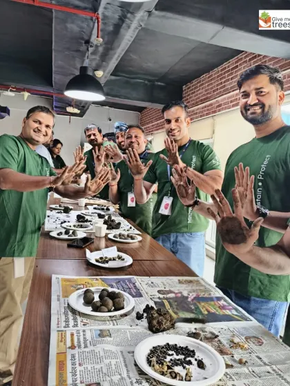 The team showing off their soil-covered hands after the seed ball workshop. This is a sign of a productive and engaging session!