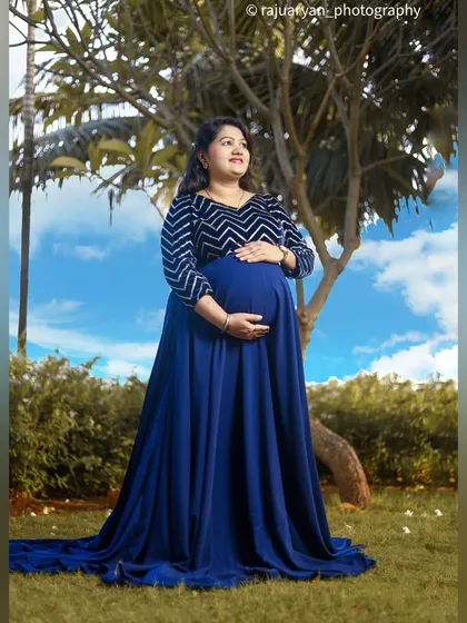 A classic outdoor maternity pose that beautifully showcases the baby bump. The mother-to-be looks towards the future, creating a portrait filled with hope and anticipation.