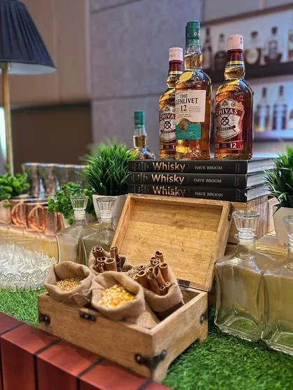 A full view of the sophisticated Whisky and Cigar bar setup. The display includes premium bottles, aromatic spices, a classic table lamp, and a well-stocked back bar, creating an authentic lounge feel.
