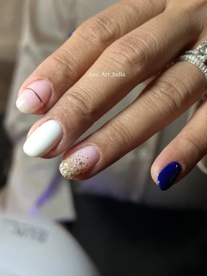 A bold and contrasting set with navy blue, white, and a full gold glitter accent nail.