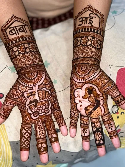 Celebrating the parents-to-be with custom portraits. One palm shows a pregnant mother with 'Mom to Be', while the other shows the father with a baby in a stroller, and 'आई' and 'बाबा' on the arms.