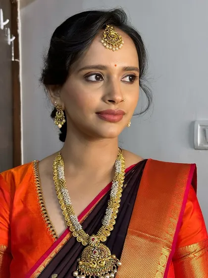 Another versatile traditional look on the same client. Here, we opted for a matte brown lip and defined eyes to complement her beautiful orange and brown saree.