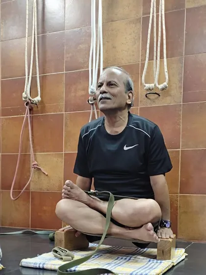 Seated in a variation of Padmasana (Lotus Pose) on blocks. This elevates the hips, making the pose more accessible and allowing for a straight spine during pranayama or meditation.