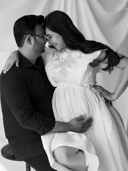 An intimate and playful pose. This black and white couple portrait captures the loving and joyful dynamic between the parents-to-be.