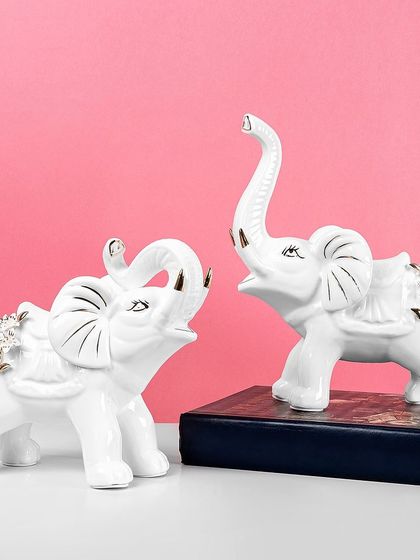 This pair of royal white elephants with gold accents brings a touch of elegance and good fortune. They are beautifully crafted and make a wonderful decorative accent for any shelf or table.