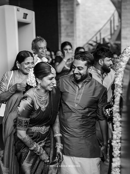 A candid black and white shot of the couple's entrance, capturing the joy and emotion of the moment.