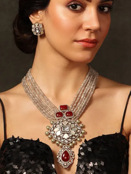 A striking heritage necklace with a large central pendant, featuring a mix of polki, red stones, and grey beads for a unique and powerful statement.
