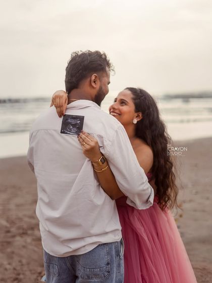 A creative and sweet way to include the sonogram. She holds the first picture of their baby on his back as they share an embrace, a secret just between them.